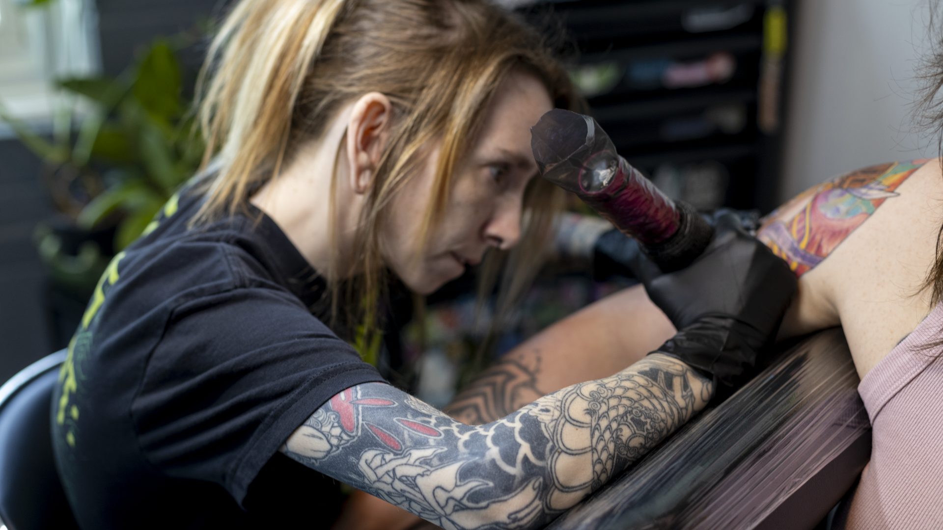 A Dawnbringer artist tattooing a client's arm