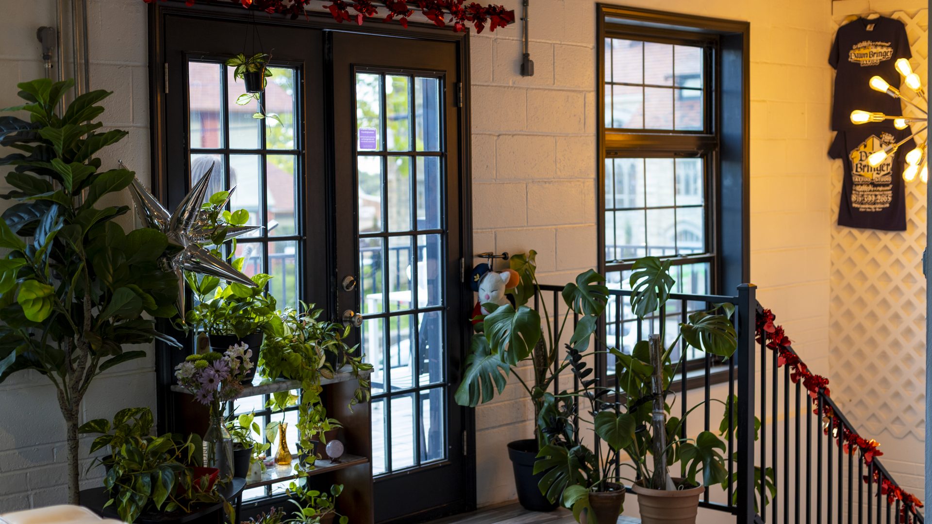 The upstairs landing — French doors out to the back balcony, framed by plants